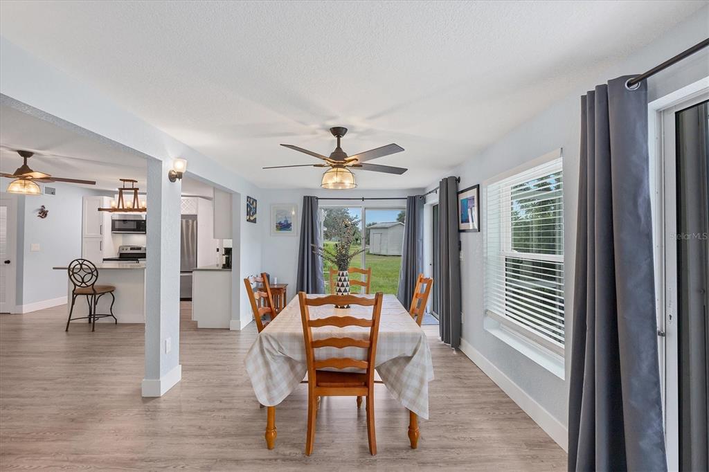 2254 Hayworth Road Port Charlotte, FL 33952 - Photo 22 of 48 a dining room with furniture a chandelier and wooden floor