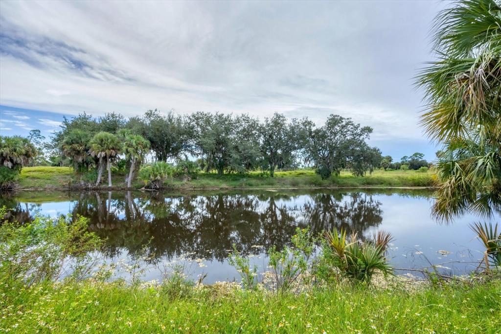 2254 Hayworth Road Port Charlotte, FL 33952 - Photo 8 of 48 a view of a lake with a yard