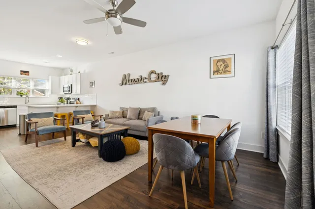 a living room with lots of furniture and view of kitchen