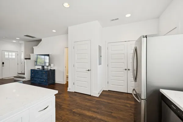 a kitchen with stainless steel appliances a refrigerator and wooden floor