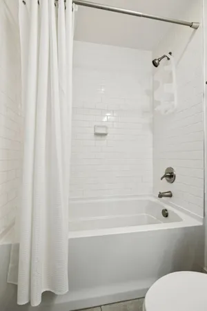 a bathroom with a toilet and a bath tub