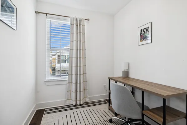 a view of a workspace with furniture and a window