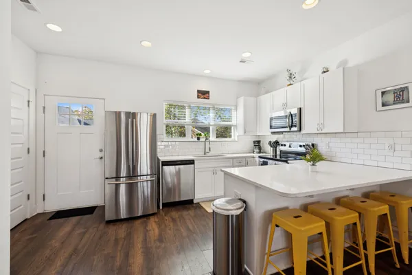 a kitchen with appliances a sink and a refrigerator
