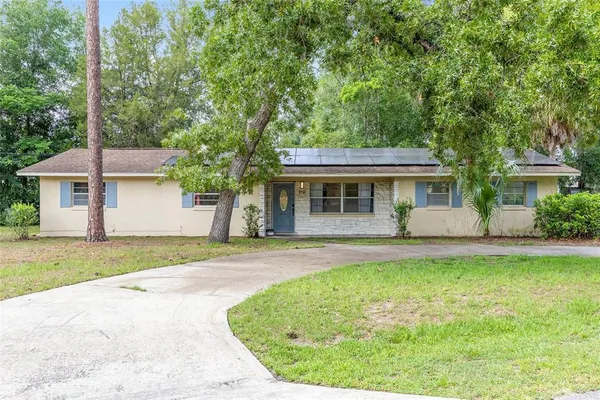 a view of a house with a yard patio and a small yard