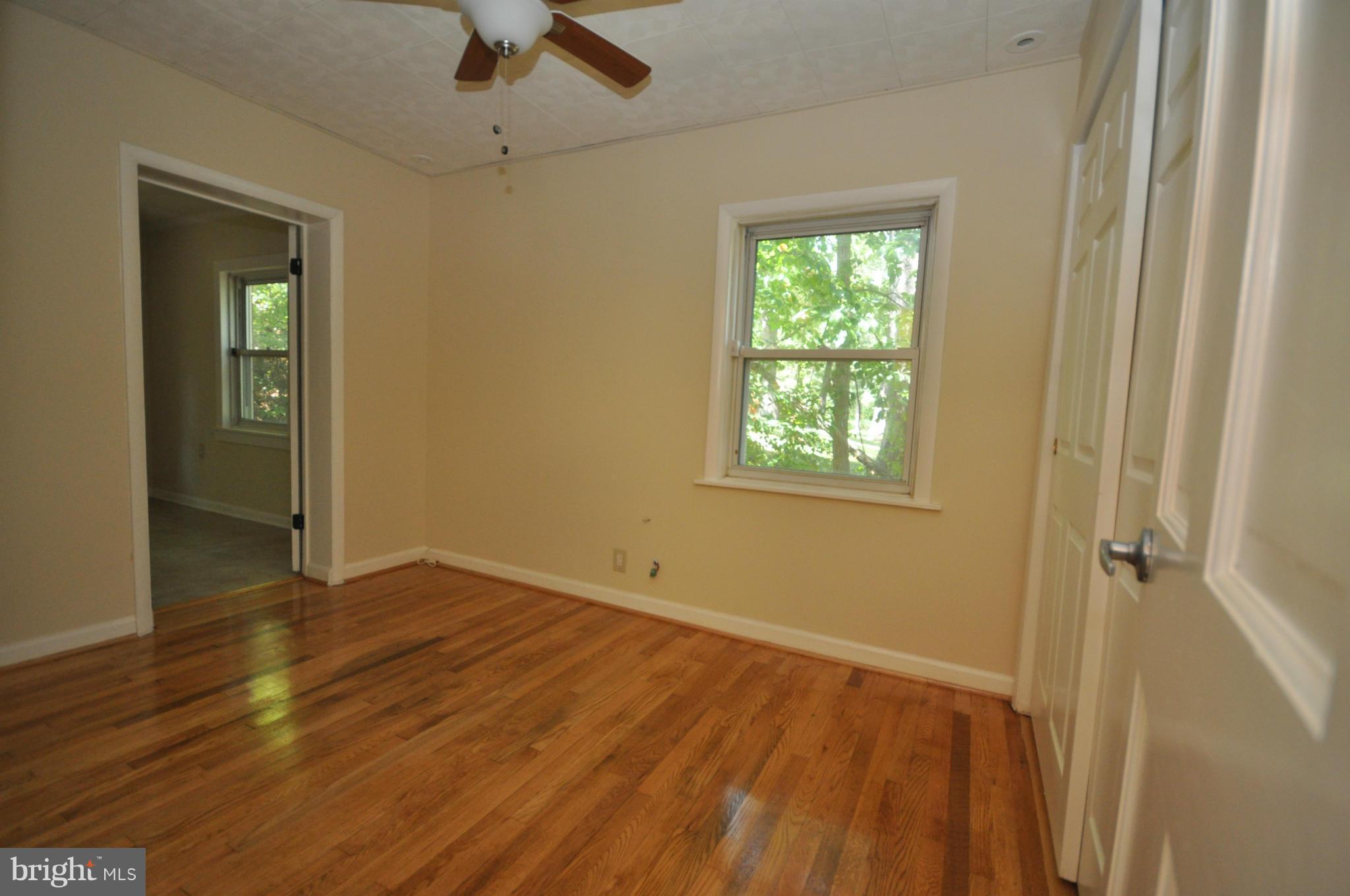 18314 Sharon Road Triangle, VA 22172 - Photo 16 of 30 a view of an empty room with wooden floor and a window
