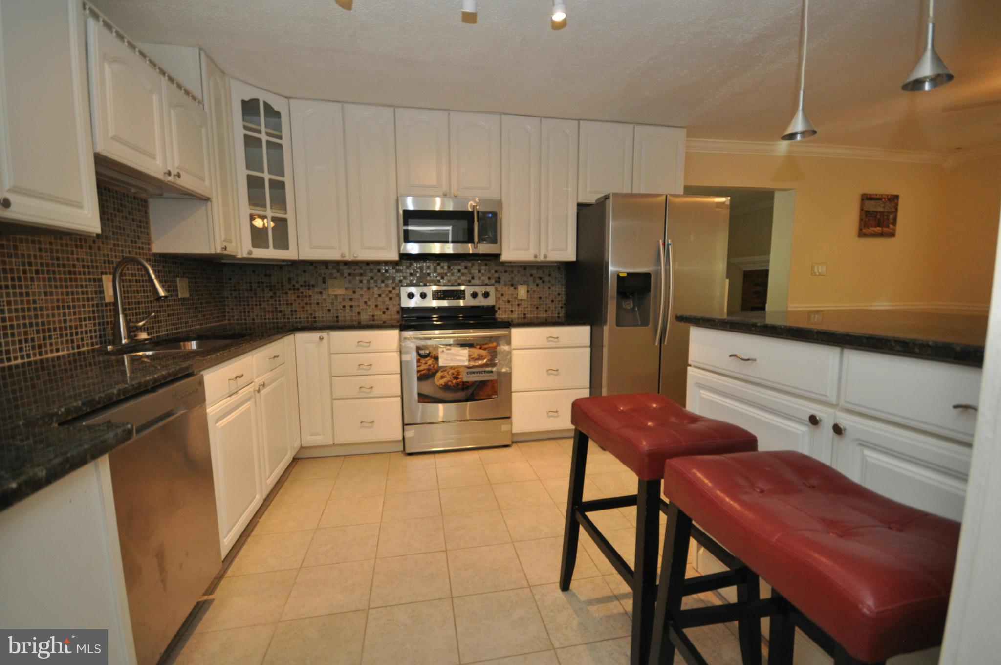18314 Sharon Road Triangle, VA 22172 - Photo 4 of 30 a kitchen with stainless steel appliances a stove a sink a microwave and a refrigerator