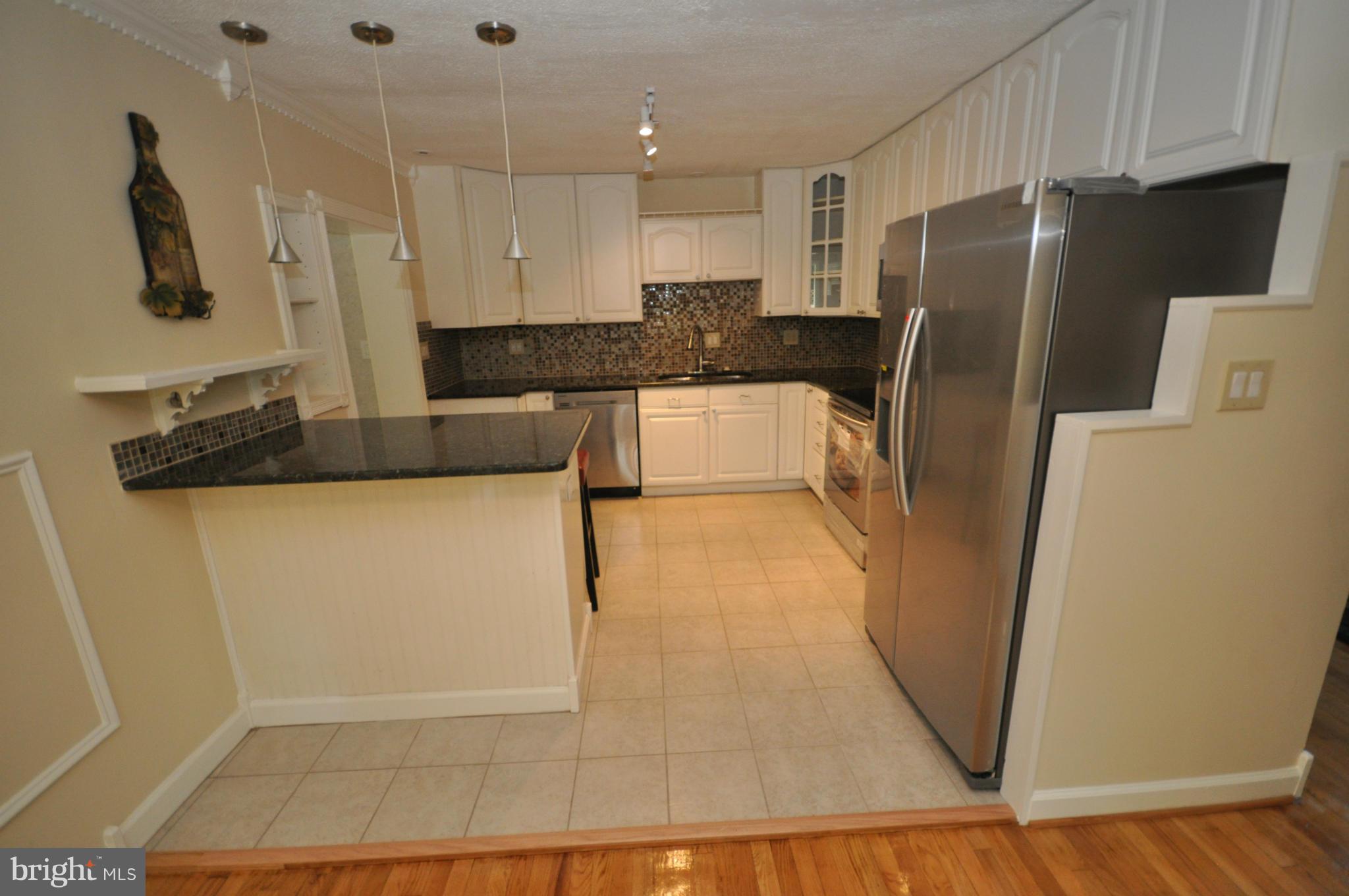 18314 Sharon Road Triangle, VA 22172 - Photo 5 of 30 a kitchen with granite countertop a refrigerator and a sink