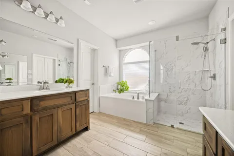 a spacious bathroom with a double vanity sink a large mirror and a bathtub