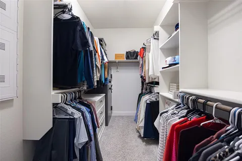 a view of walk in closet with clothes and shoes