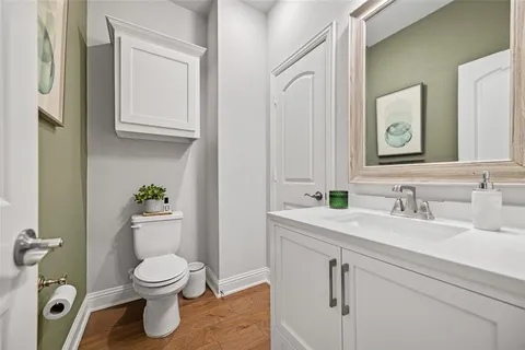 a bathroom with a granite countertop toilet sink and mirror