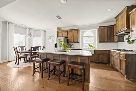 a kitchen with a table chairs sink and cabinets