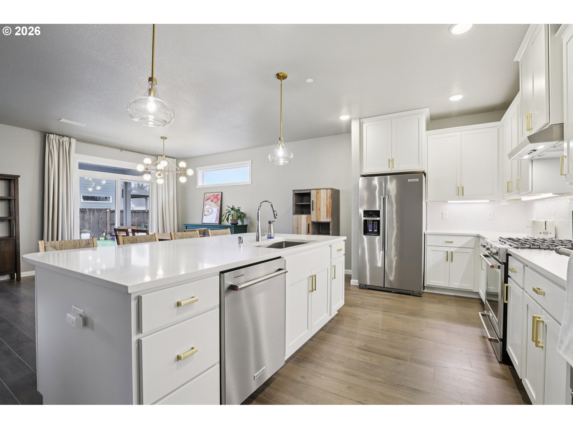604 Northwest 25th Way Battle Ground, WA 98604 - Photo 12 of 33 a kitchen with stainless steel appliances kitchen island granite countertop a refrigerator a sink dishwasher a stove with white cabinets