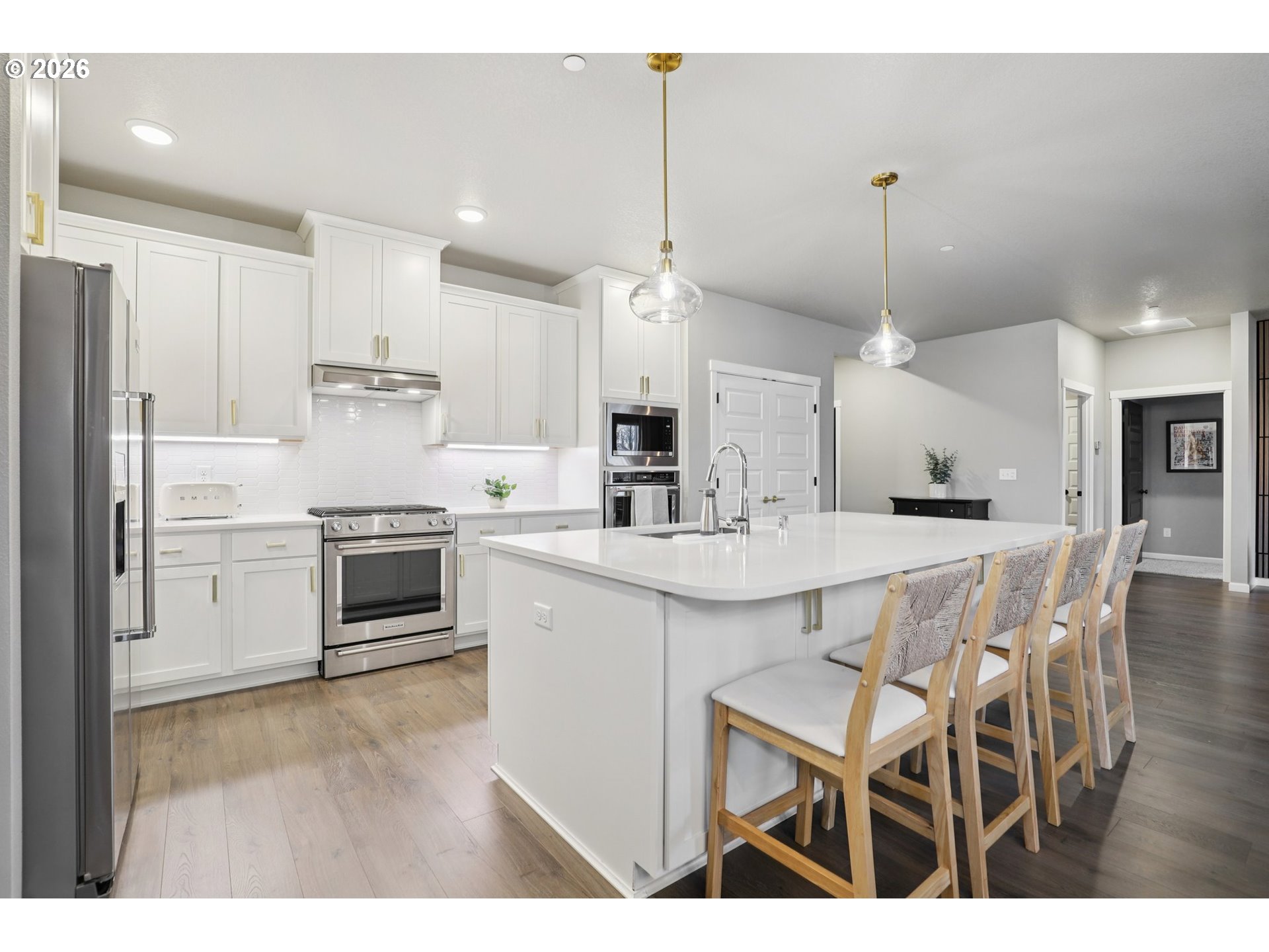 604 Northwest 25th Way Battle Ground, WA 98604 - Photo 15 of 33 a kitchen with stainless steel appliances kitchen island granite countertop a sink a stove a refrigerator and white cabinets with wooden floor