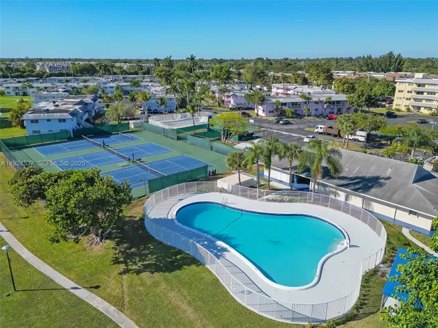 an aerial view of a swimming pool with outdoor seating