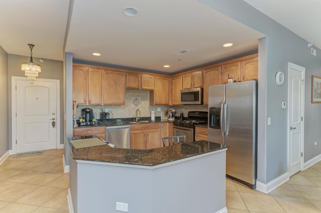 1210 Foxdale Drive, Unit 105 Addison, IL 60101 - Photo 11 of 25 a kitchen with granite countertop a refrigerator and a sink