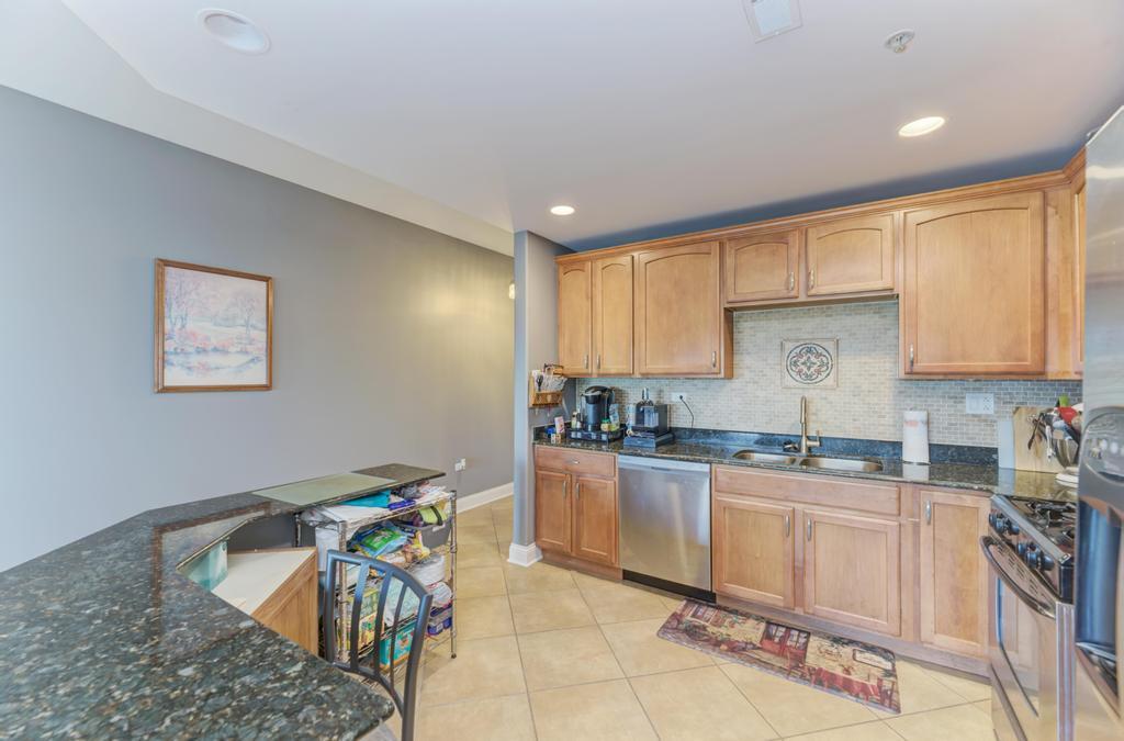 1210 Foxdale Drive, Unit 105 Addison, IL 60101 - Photo 13 of 25 a kitchen with granite countertop sink cabinets and stainless steel appliances