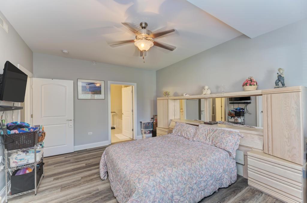 1210 Foxdale Drive, Unit 105 Addison, IL 60101 - Photo 17 of 25 a spacious bedroom with a bed and a flat screen tv