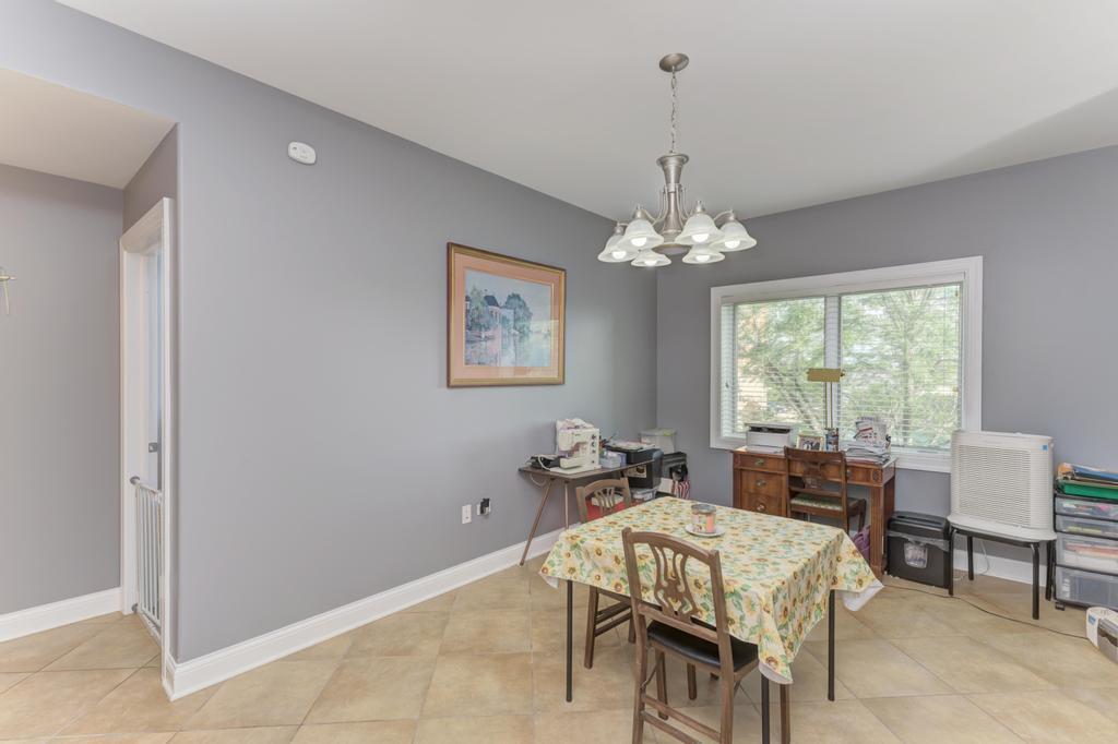 1210 Foxdale Drive, Unit 105 Addison, IL 60101 - Photo 8 of 25 a dining room with furniture a rug and a chandelier