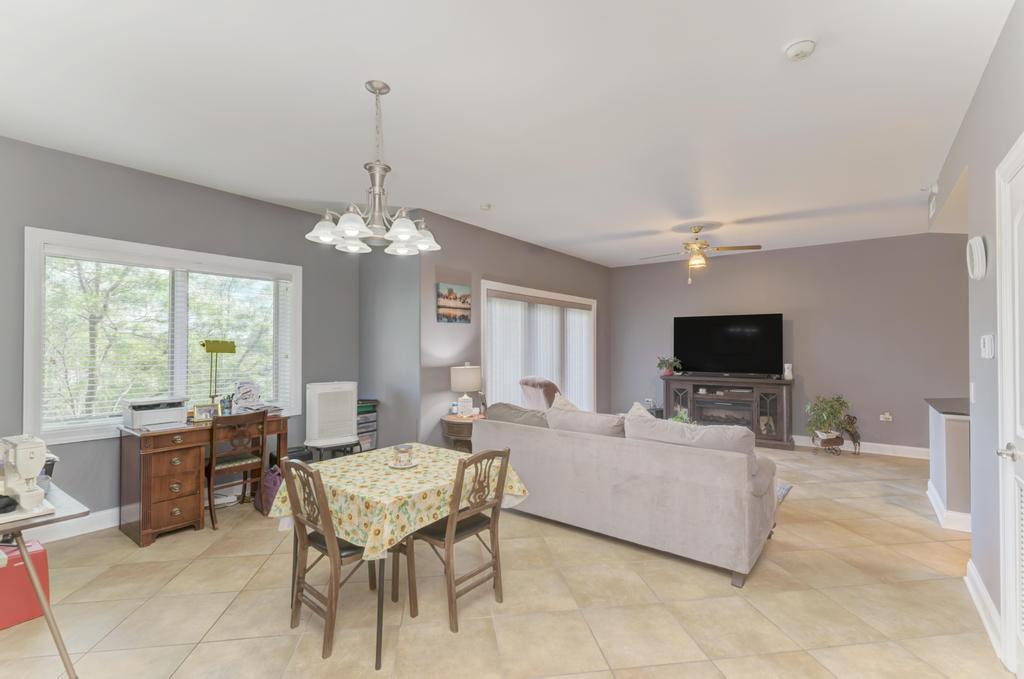 1210 Foxdale Drive, Unit 105 Addison, IL 60101 - Photo 9 of 25 a living room with furniture a flat screen tv and a large window