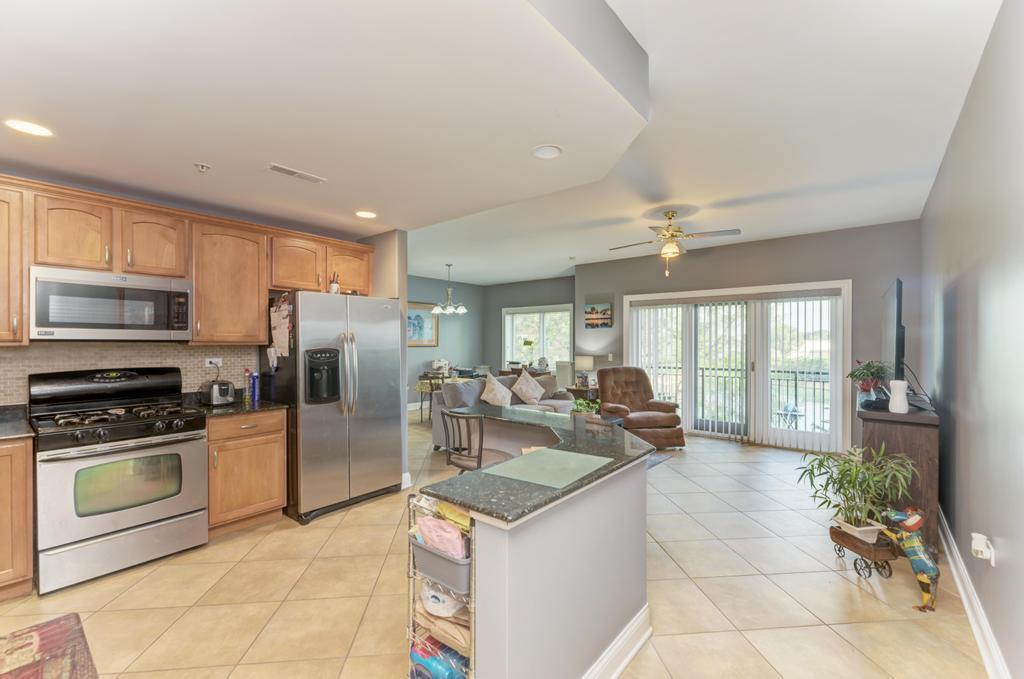 1210 Foxdale Drive, Unit 105 Addison, IL 60101 - Photo 10 of 25 a kitchen with stainless steel appliances granite countertop a sink stove and refrigerator