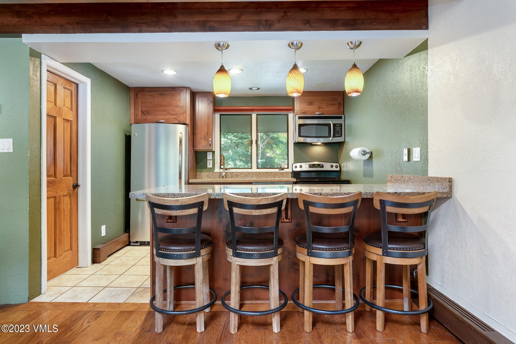 2823 Kinnickinnick Road, Unit 8 Vail, CO 81657 - Photo 1 of 23 a dining room with furniture a window and stainless steel appliances