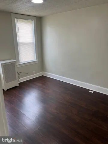 an empty room with wooden floor and window
