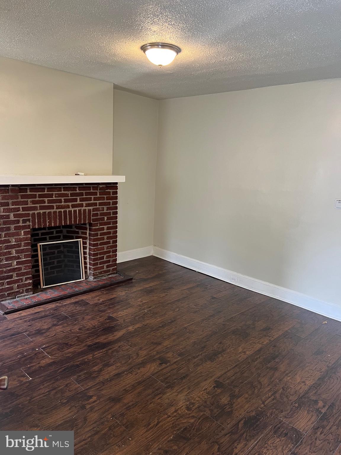 2910 Poplar Terrace Baltimore, MD 21216 - Photo 14 of 14 an empty room with wooden floor and fireplace