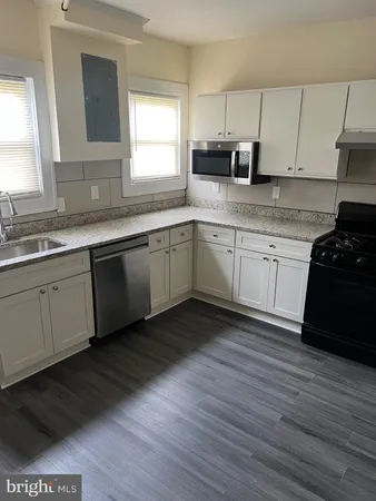 a kitchen with granite countertop cabinets stainless steel appliances a sink and a window