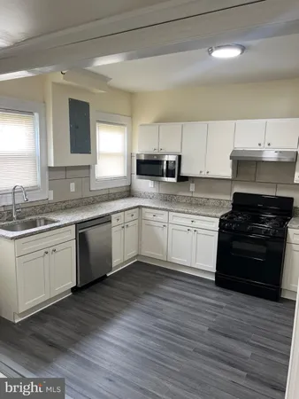 a kitchen with a sink cabinets and wooden floor