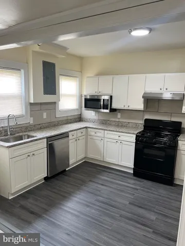 a kitchen with a sink cabinets and wooden floor