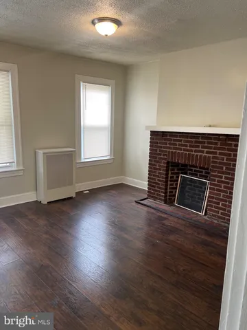 an empty room with wooden floor and fireplace