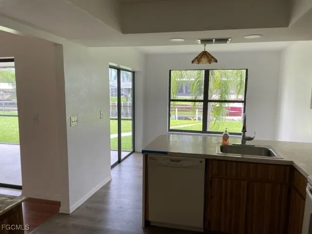 a kitchen with a sink and wooden floor