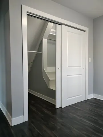 an empty room with wooden floor and closet