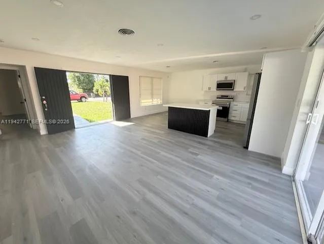 a view of a kitchen with furniture and wooden floor