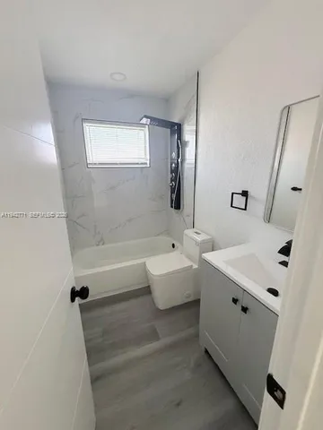 a bathroom with a tub sink and mirror