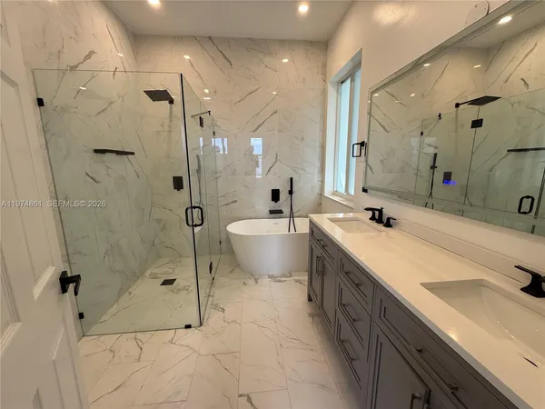 a spacious bathroom with a double vanity sink mirror and shower