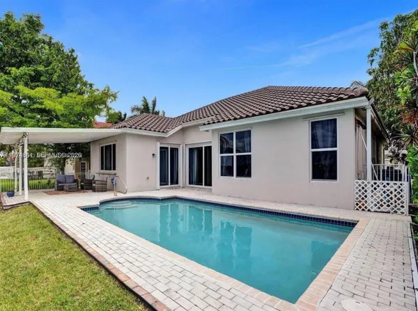 a view of a house with backyard and sitting area