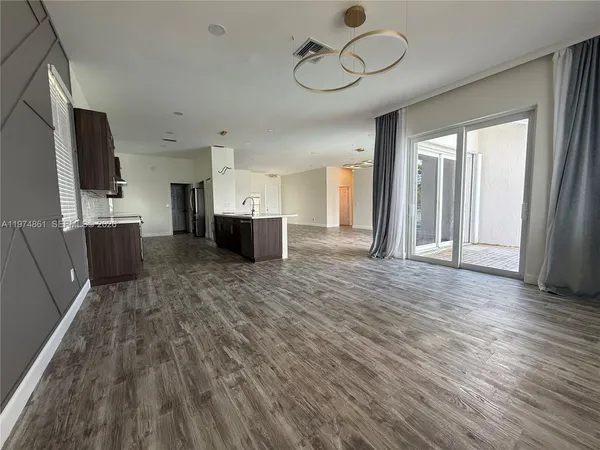 a view of a kitchen with a sink and dishwasher a refrigerator with wooden floor