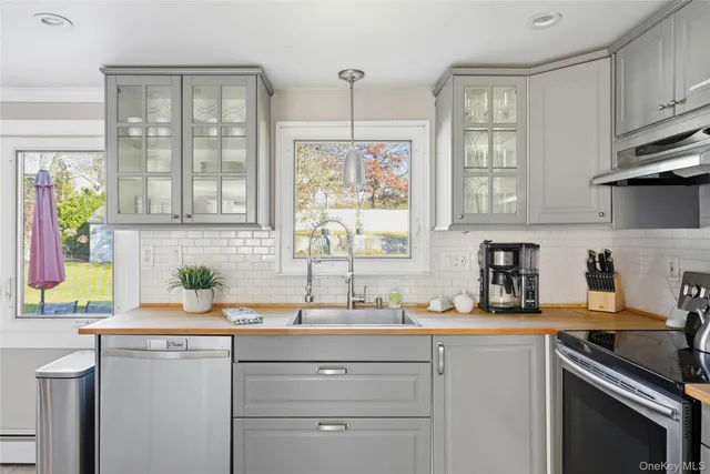 a kitchen with a sink cabinets stainless steel appliances and a window