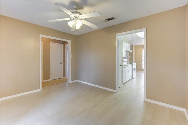 an empty room and chandelier fan