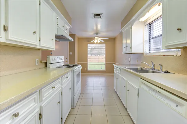 a kitchen with granite countertop white cabinets and appliances