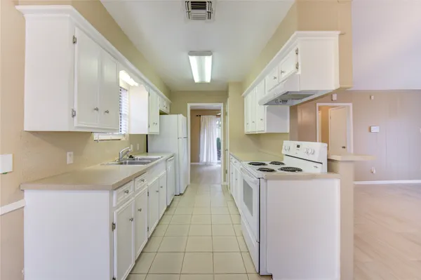 a kitchen with a stove sink and cabinets