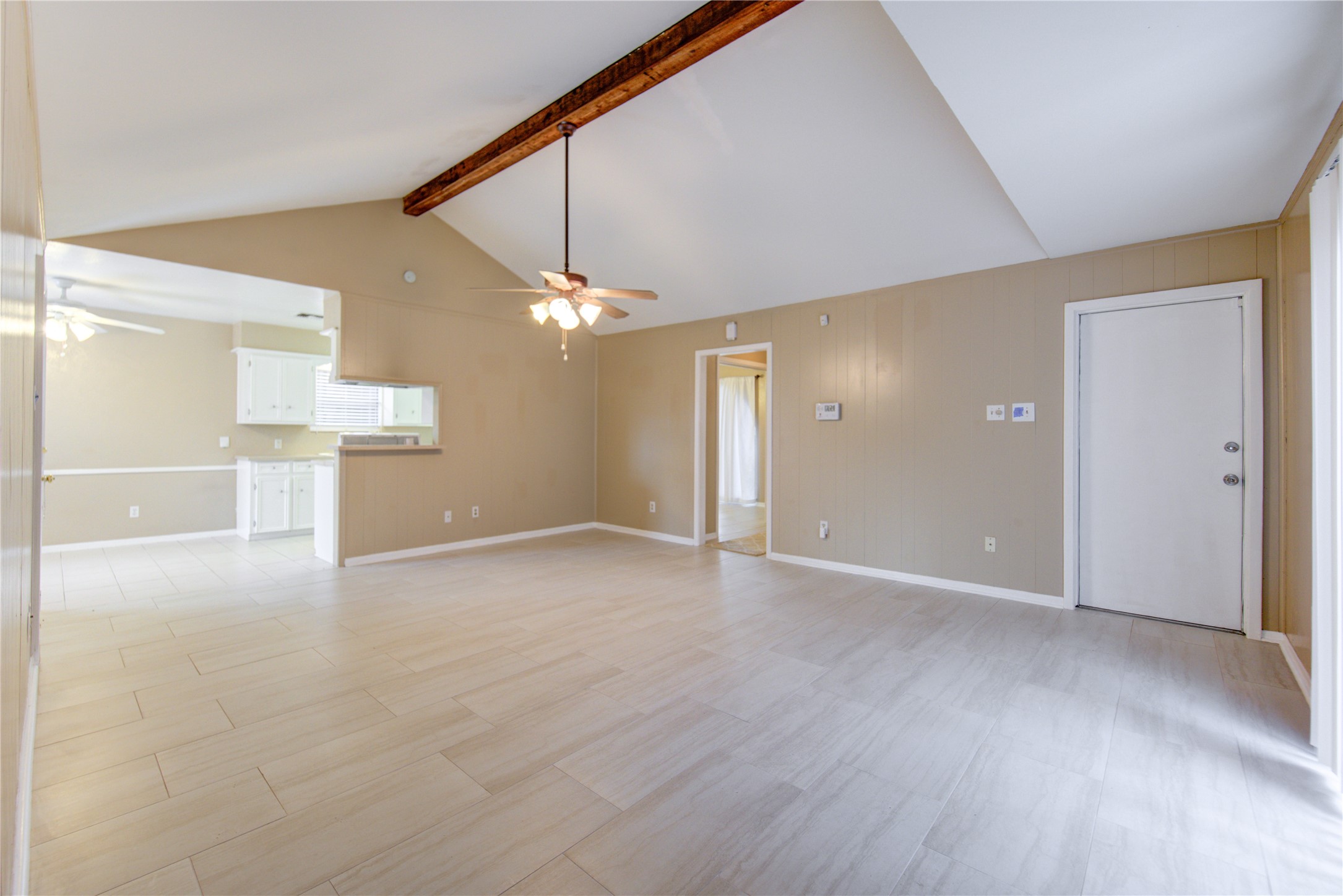 3412 Avenue R Rosenberg, TX 77471 - Photo 22 of 43 an empty room with wooden floor and a kitchen