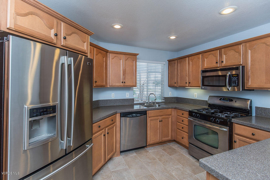 1745 Empty Saddle Road Simi Valley, CA 93063 - Photo 12 of 29 a kitchen with granite countertop a refrigerator stove and microwave