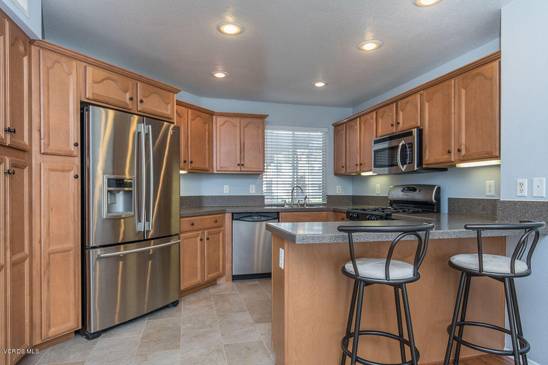 1745 Empty Saddle Road Simi Valley, CA 93063 - Photo 13 of 29 a kitchen with stainless steel appliances granite countertop a refrigerator a stove top oven a sink and dishwasher