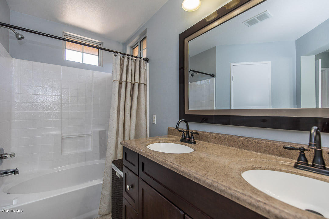 1745 Empty Saddle Road Simi Valley, CA 93063 - Photo 21 of 29 a bathroom with a granite countertop sink and a mirror