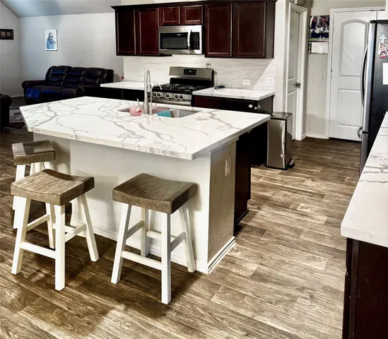 a kitchen with stainless steel appliances kitchen island granite countertop a sink and cabinets