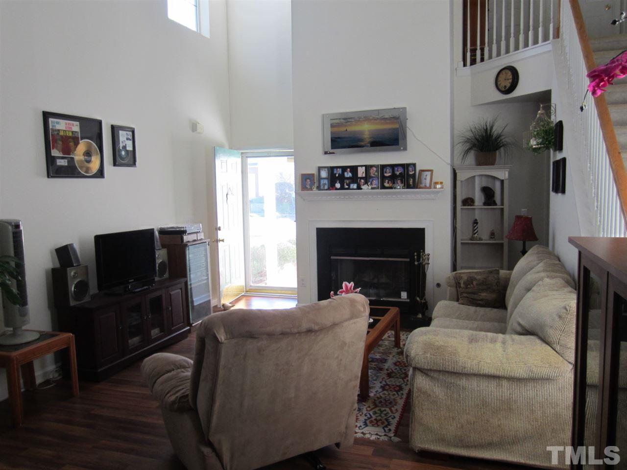 9901 Treymore Drive Raleigh, NC 27617 - Photo 2 of 25 a living room with furniture a flat screen tv and a fireplace