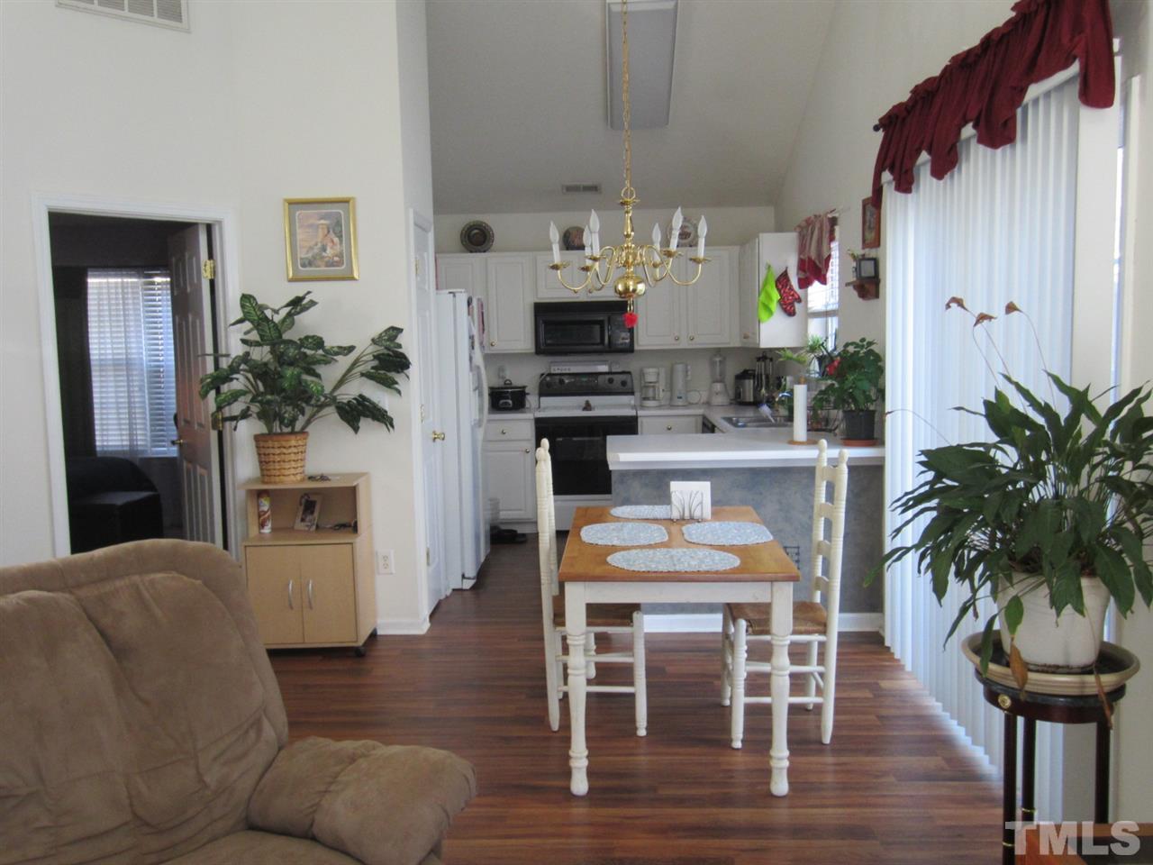 9901 Treymore Drive Raleigh, NC 27617 - Photo 3 of 25 a living room with furniture a potted plant and kitchen view