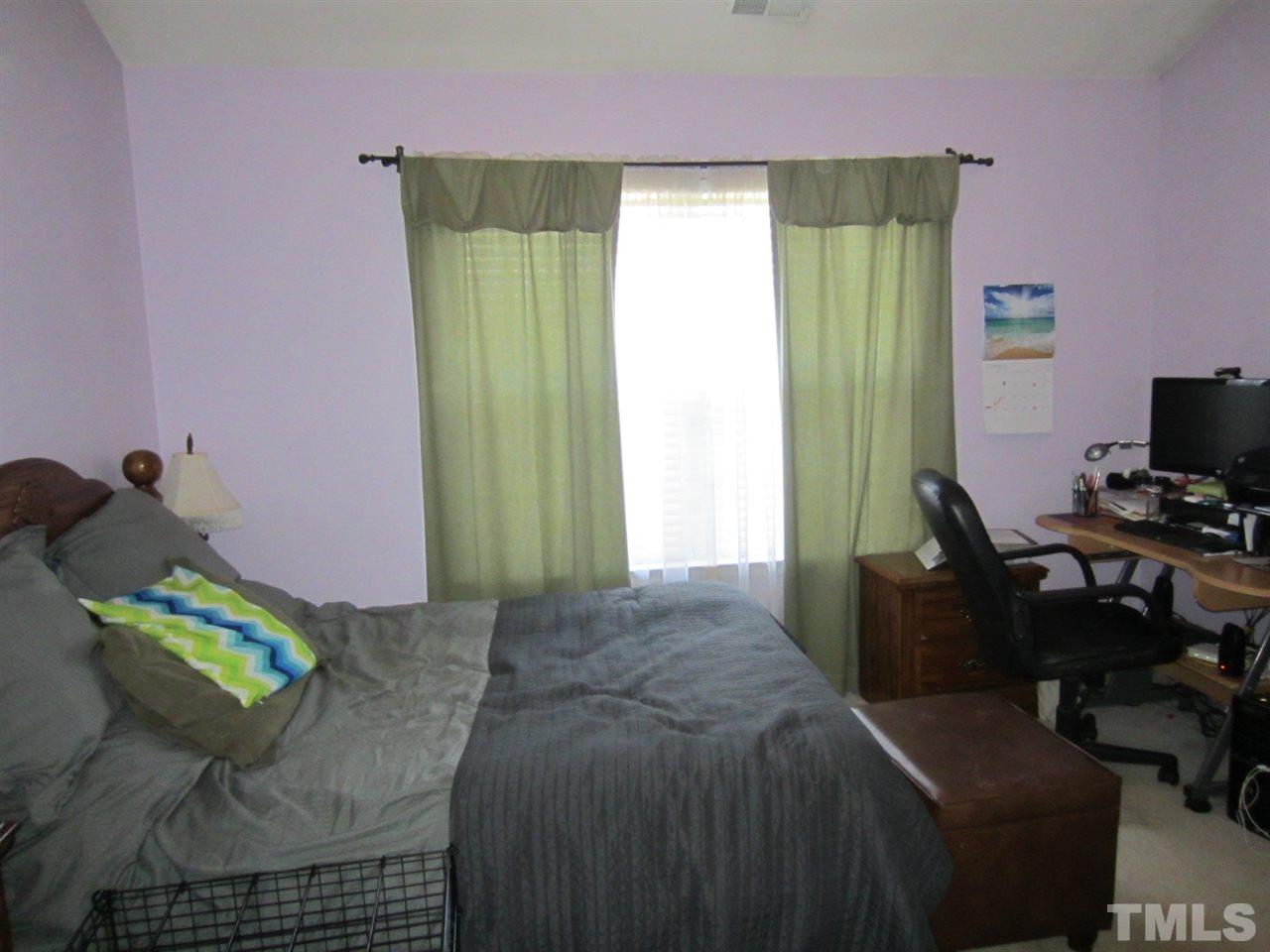 9901 Treymore Drive Raleigh, NC 27617 - Photo 21 of 25 a bedroom with a bed and a chair